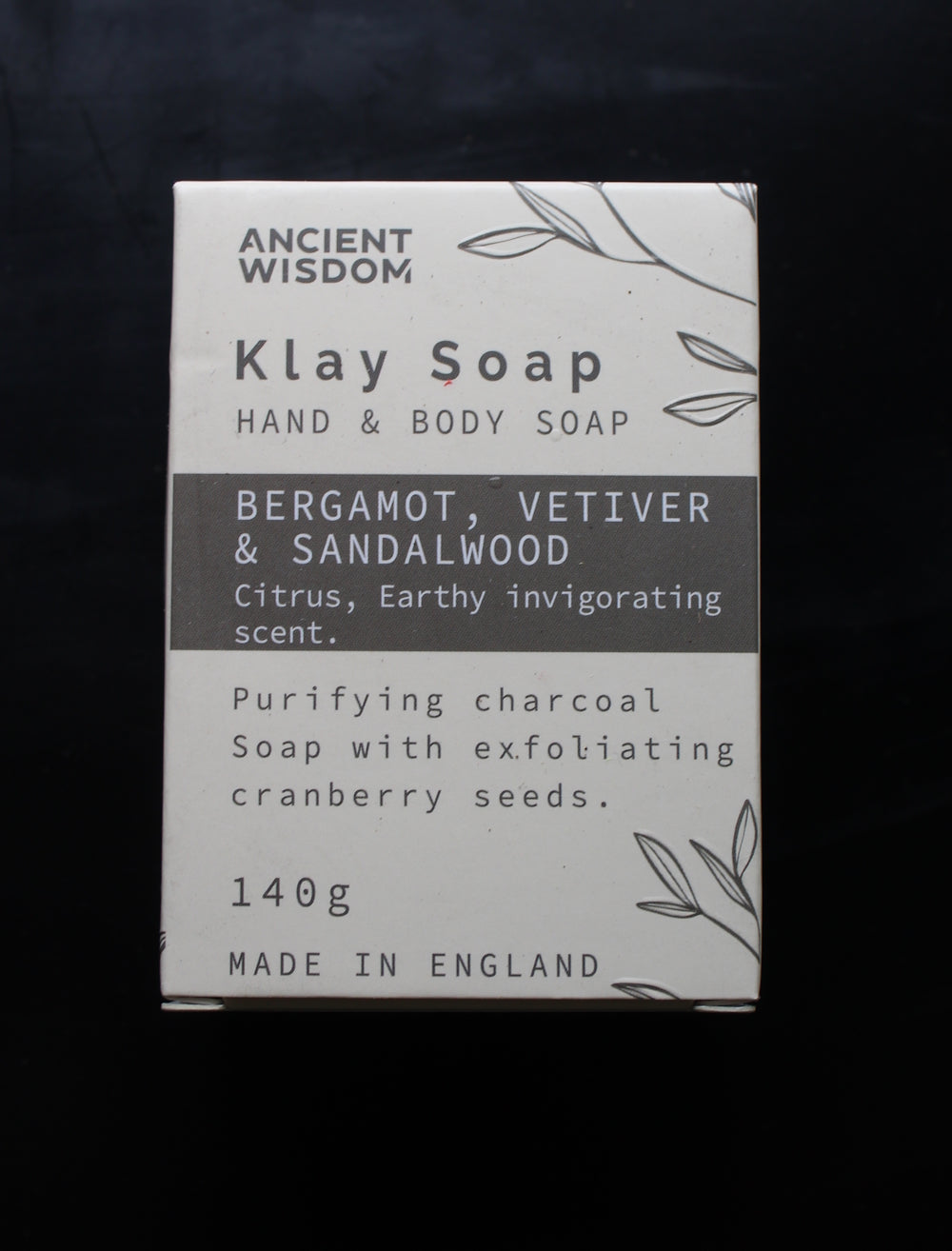 A rectangular box of Ancient Wisdom Klay Soap Hand & Body Soap, featuring a white and dark gray design with text detailing the scent and ingredients, set against a dark background.