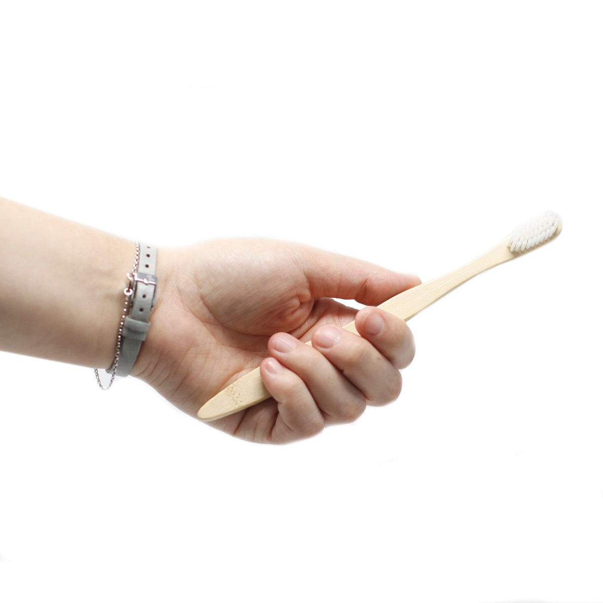 Hand holding a wooden toothbrush on a white background