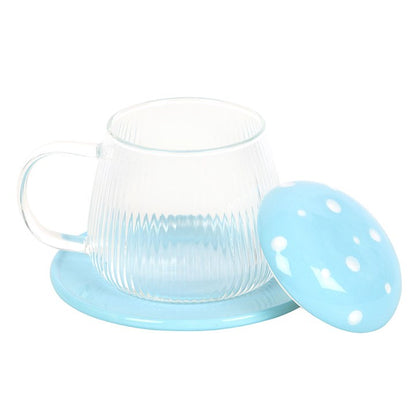 Clear glass teacup with a light blue lid and base on a white background