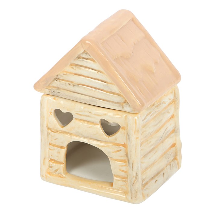 Small house-shaped ceramic oil burner with a beige roof and heart designs on a white background