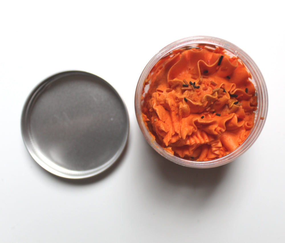 Top view of open whipped soap jar with metal lid