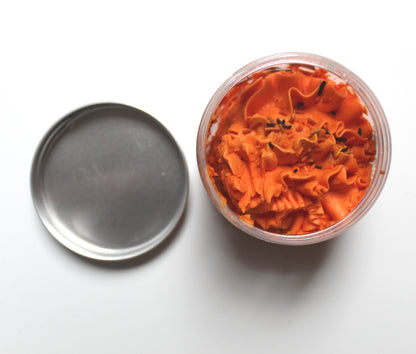 Top view of open whipped soap jar with metal lid