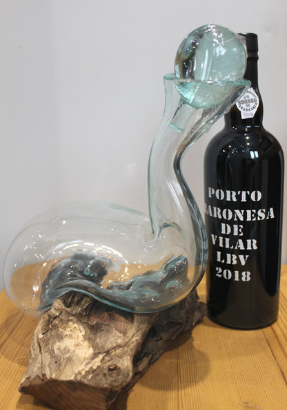 Glass decanter with a bottle of Porto wine on a wooden surface