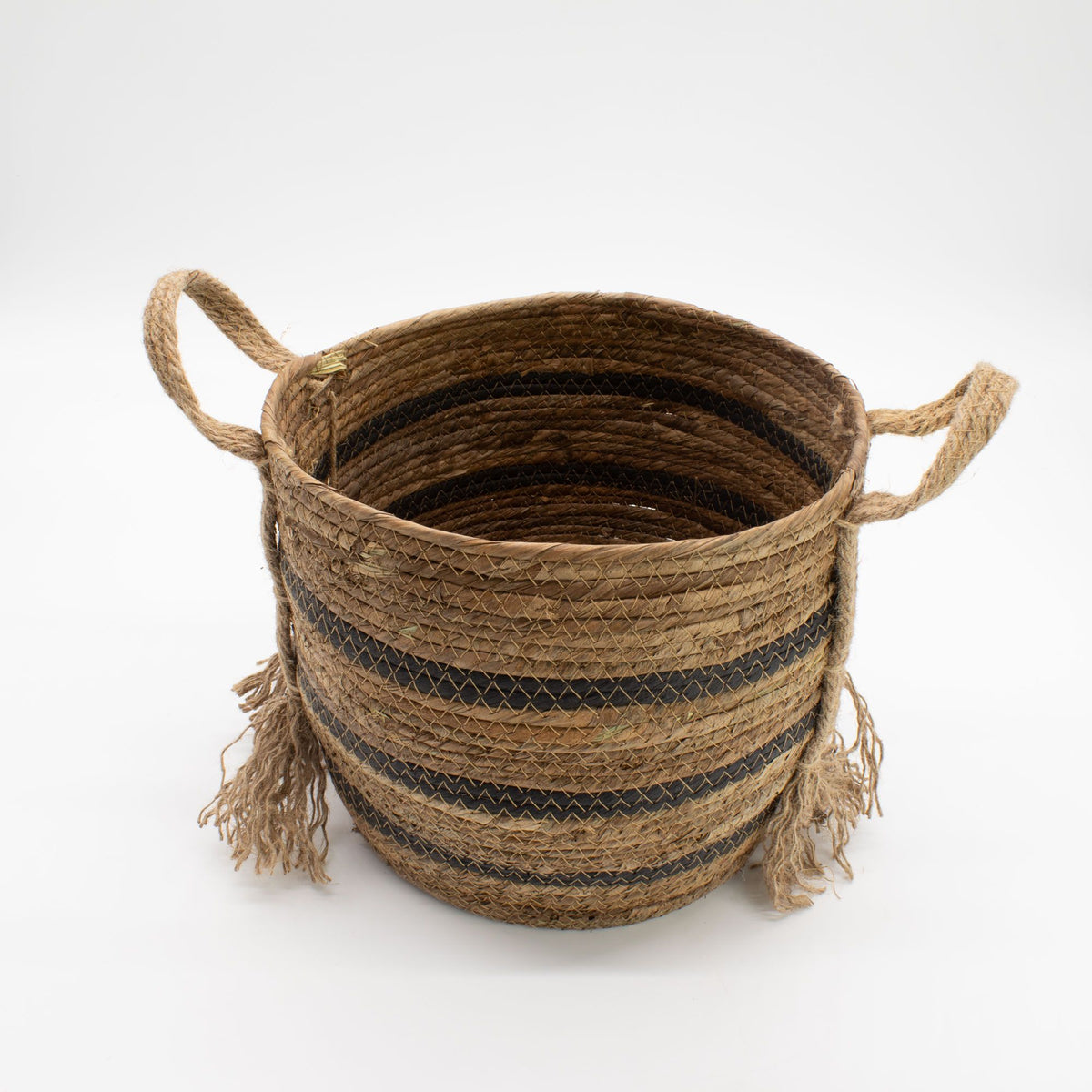 Woven basket with handles and fringes on a white background