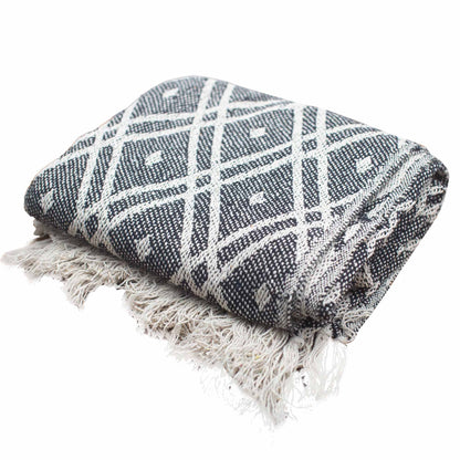 Woven blanket with geometric pattern and fringes on a white background