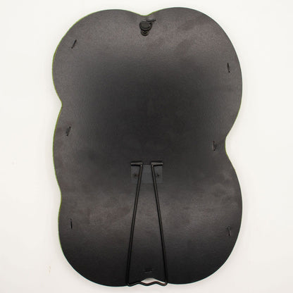 Black back of a mirror showing hook and stand with background