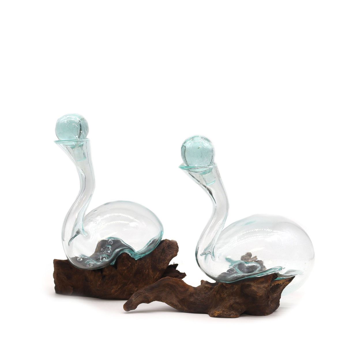 Two glass unique wine decanters on a wooden base with a white background