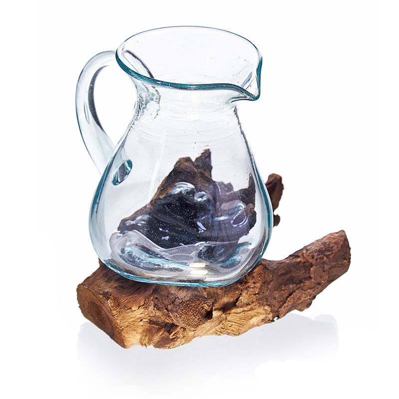 Molten Clear glass pitcher placed on a wooden log against a white background
