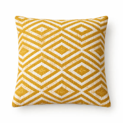 Yellow and white geometric patterned pillow on a white background