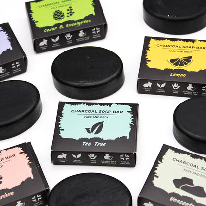 Collection of charcoal soap bars with their packaging on a white background