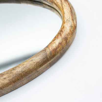 Detail of a pebble shaped Wooden mirror on a white background