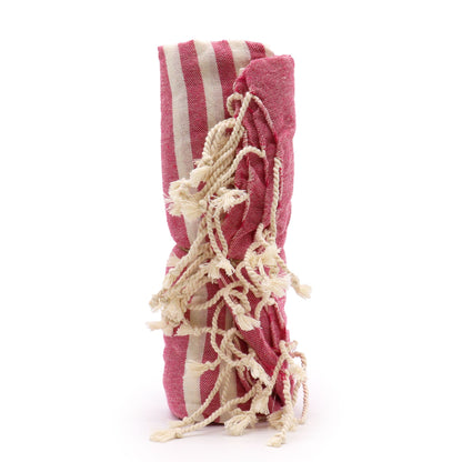 Pink and white striped towel with tassels on a white background