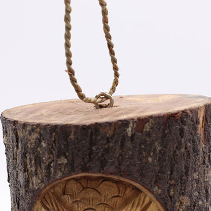 Wooden bird feeder with rope attachment on a white background