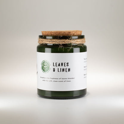 Candle jar Woodwick Soy Candle Leaves Linen labeled 'Leaves & Linen' with a cork lid on a light background