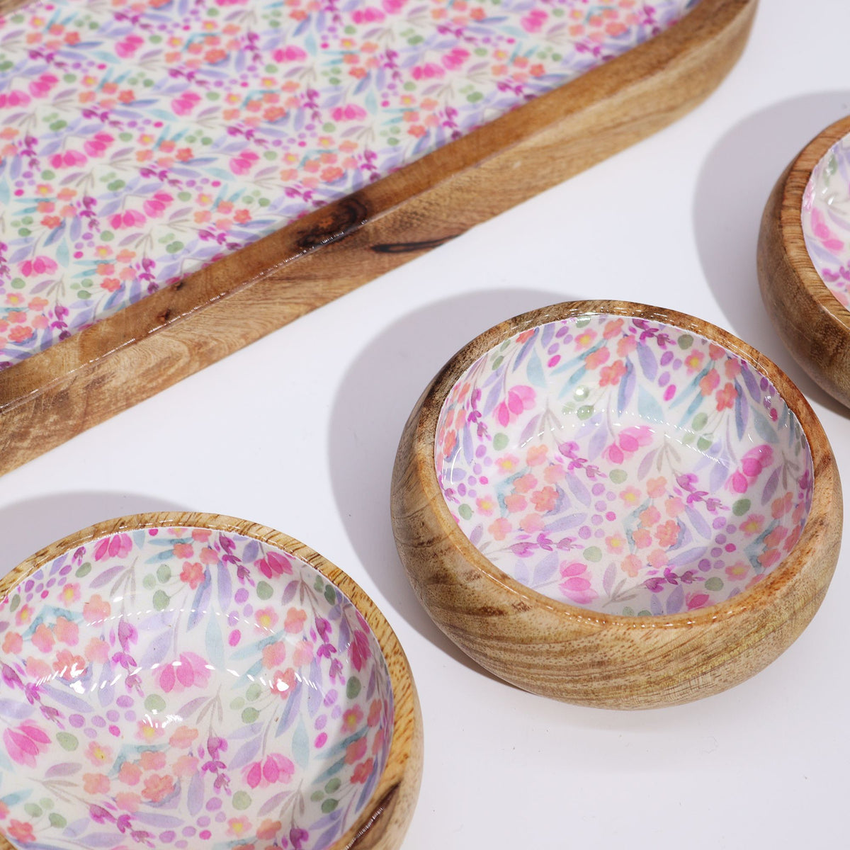 Wooden bowls with floral interior design on a white surface