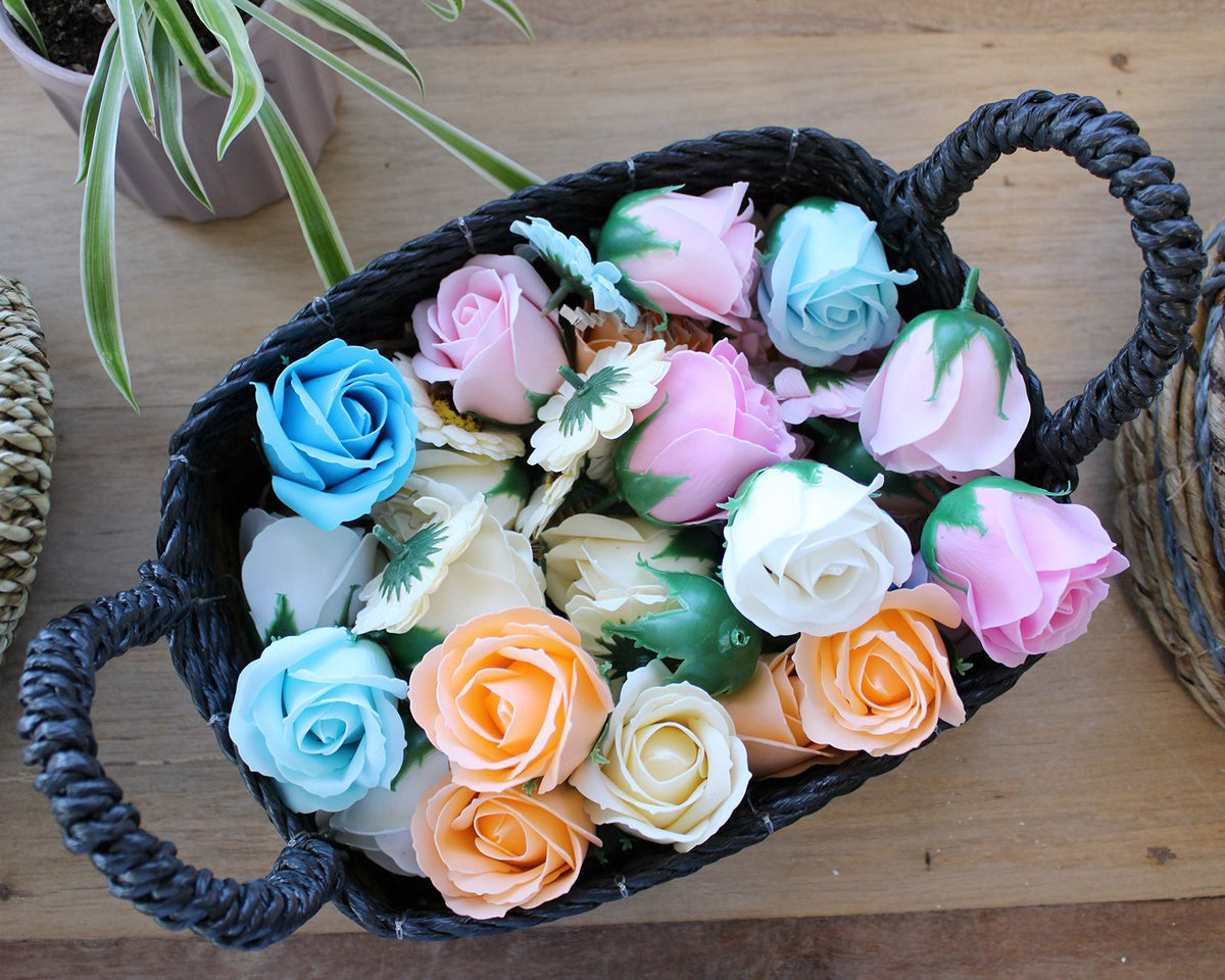 Basket filled with colorful artificial flowers on a wooden surface
