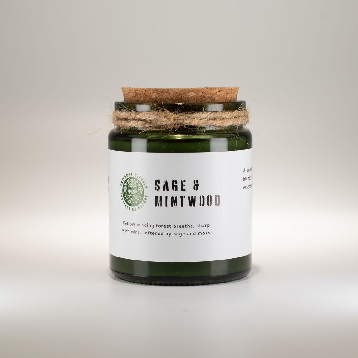 Scented candle jar labeled 'Sage & Mintwood' on a light background