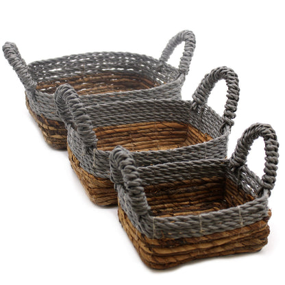 Three woven baskets with gray rope handles on a white background