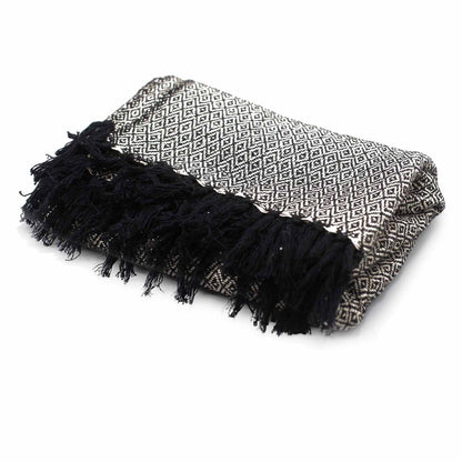 Black and white patterned blanket with fringes on a white background