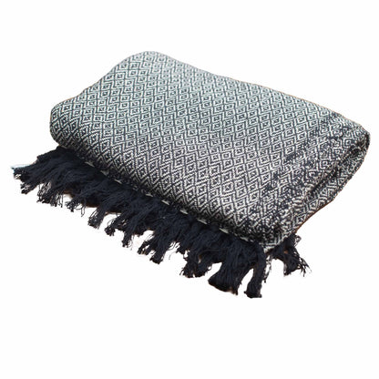 Textile with geometric pattern and black tassels on a white background