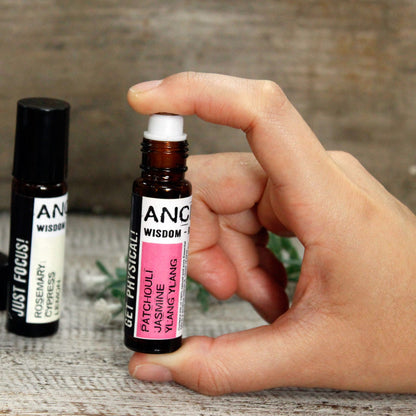 Hand holding a bottle of  Essential Oil Roll on  with another bottle in the background.