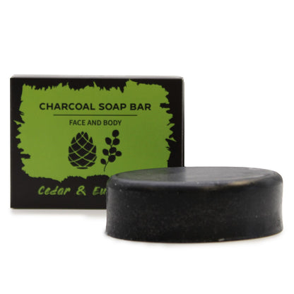 Charcoal soap bar with packaging labeled ' Eucalyptus Cedarwood Charcoal Soap Bar' on a white background