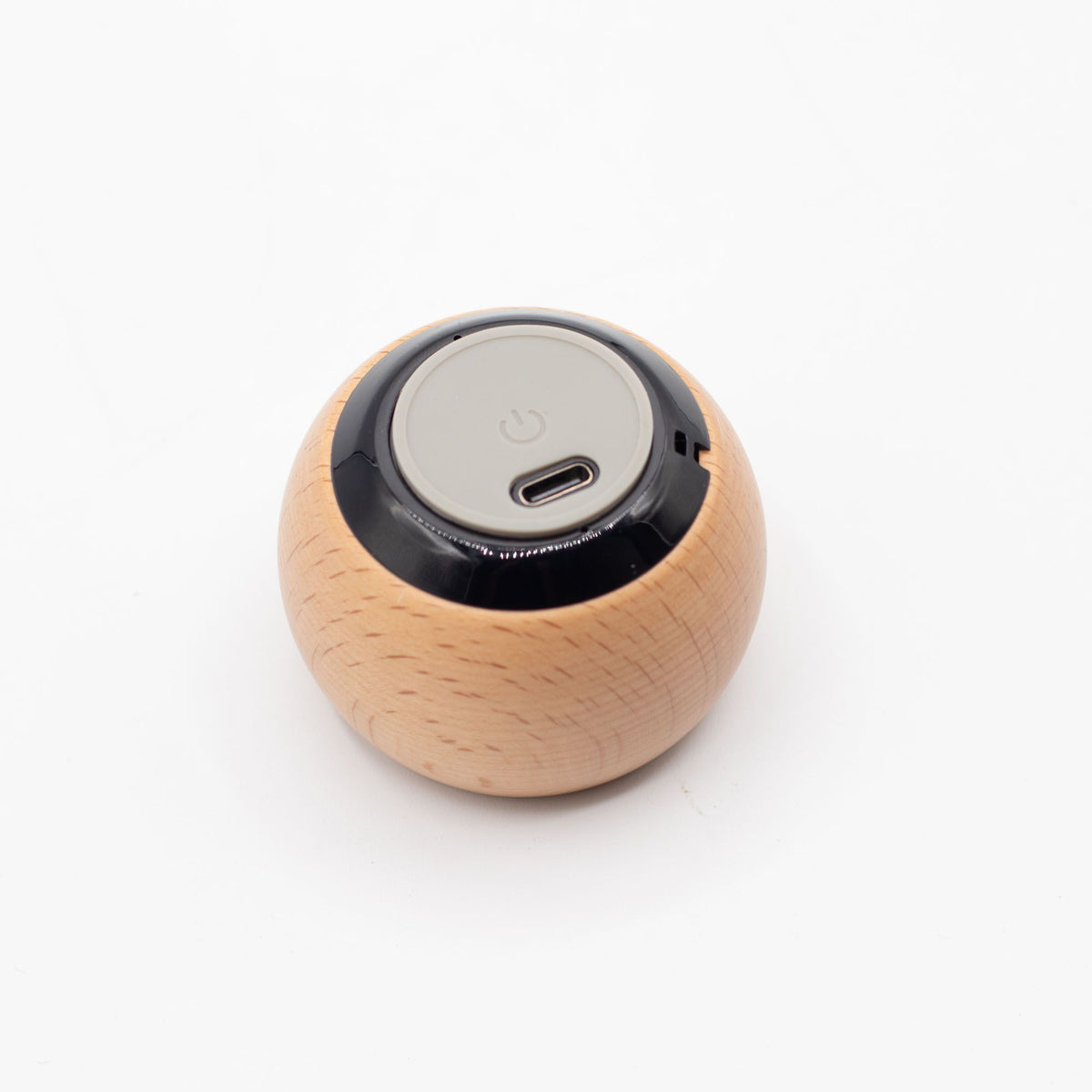 Bottom of round wooden pocket Bluetooth speaker on a white background