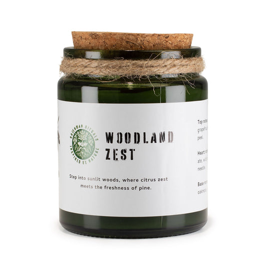 Candle jar labeled 'Woodland Zest' with a cork lid on a white background