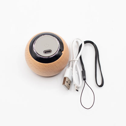 Wooden speaker with USB cable and lanyard on a white background