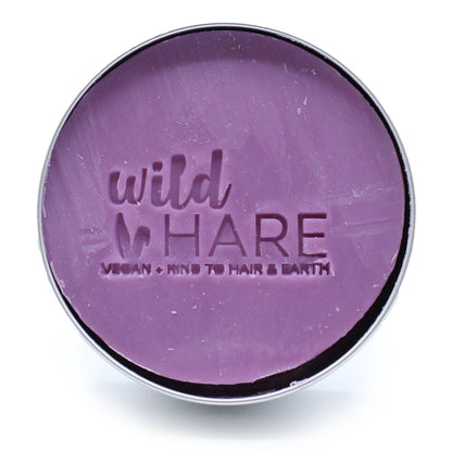 Open container of purple 'wild HARE' Tutti Frutti Solid Shampoo Bar on a white background
