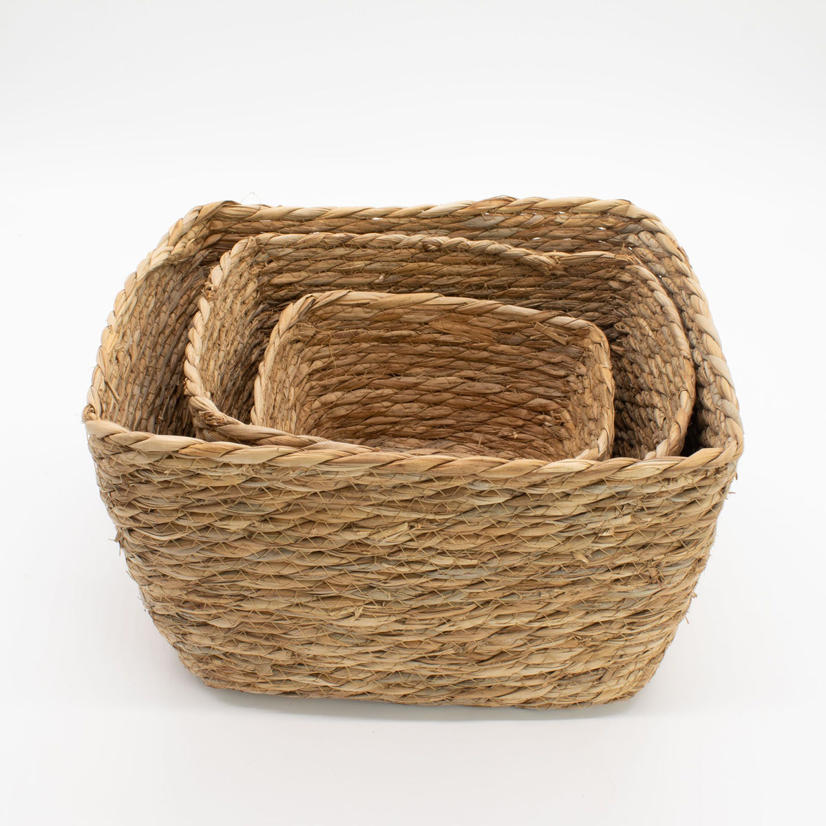 Set of three woven baskets on a white background