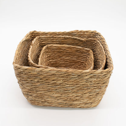 Set of three woven baskets on a white background