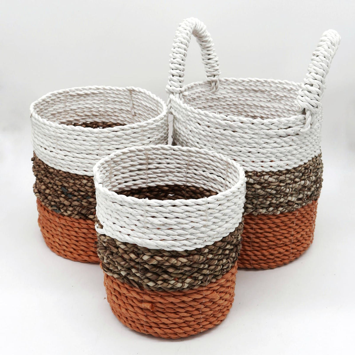 Three woven baskets with striped patterns on a white background